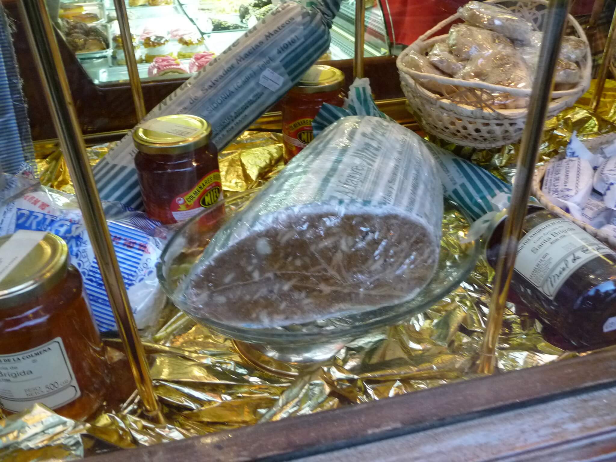 Alfajor de Medina Sidonia sobre un plato, con frutos secos y cobertura de azúcar
